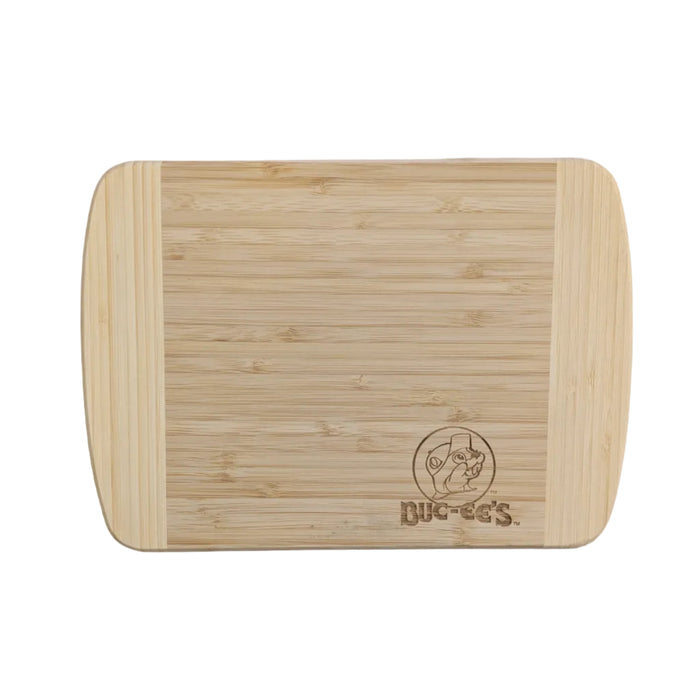 Top-down view of a Buc-ee's Cutting Board. a rectangular, multi-tone bamboo Hana cutting board with vertical light bands, featuring a detailed laser-etched Buc-ee's beaver logo in the lower right corner. Displayed on a clean white background.