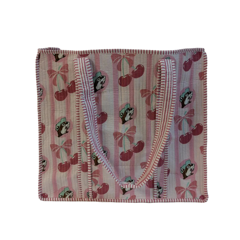 A large Buc-ee's Cherry Tote Bag. The bag features a pink and white vertical stripe pattern printed with Buc-ee's beaver mascots, pink cherries, and bows, finished with matching striped shoulder straps. Displayed on a white background.