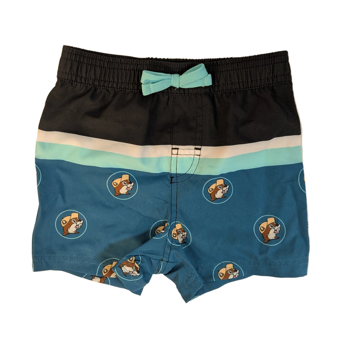 Infant-sized Buc-ee's Logo Colorblock swim shorts with a black and teal colorblock design and beaver logo pattern. The waistband features a small, fixed mint green decorative bow. Displayed on a clean white background.