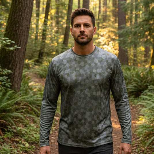 Buc-ee’s Long Sleeve Performance AOP Camo Shirt on a man in the forest.
