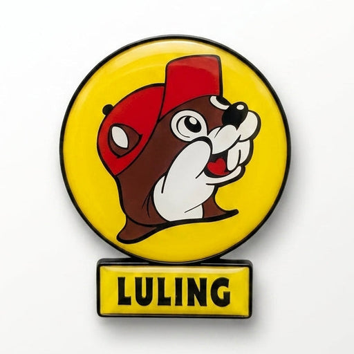 A circular yellow enamel magnet featuring the smiling Buc-ee's beaver wearing a red hat, with a small rectangular yellow sign attached directly below reading "LULING" in black text.