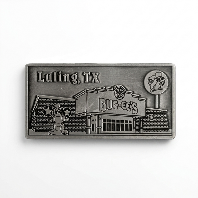 A rectangular antique pewter metal magnet with 3D relief detailing of the Buc-ee's Luling storefront. Features "Luling, TX" engraved in the upper left corner, the Buc-ee's store building with main entrance, the beaver mascot statue out front, and the tall roadside lollipop sign on the right.