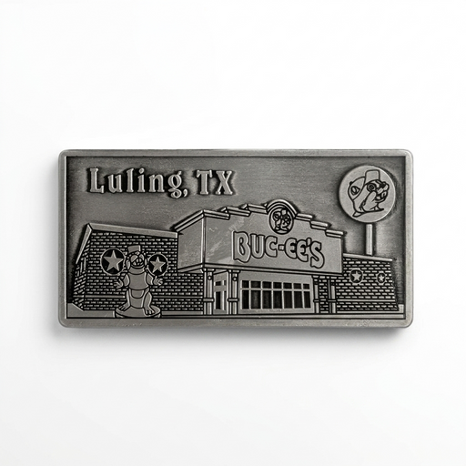 A rectangular antique pewter metal magnet with 3D relief detailing of the Buc-ee's Luling storefront. Features "Luling, TX" engraved in the upper left corner, the Buc-ee's store building with main entrance, the beaver mascot statue out front, and the tall roadside lollipop sign on the right.