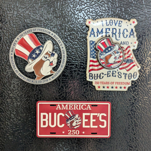 Three patriotic-themed pins on a textured black surface