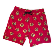 A flat lay view of bright red swim shorts featuring an all-over repeat pattern of the circular yellow and red Buc-ee’s beaver logo. The shorts include a black drawstring at the elastic waistband and are laid flat against a neutral background to show the design and fit.