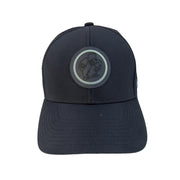 A front-facing view of a structured navy blue performance cap resting on a white background. The center features a circular, dark tonal rubber patch showcasing the Buc-ee's beaver mascot, outlined by a thin mint green ring.