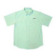 A front view of a solid sea-foam green, short-sleeved performance fishing shirt laid flat on clean white background. The shirt includes a button-down collar, a full button front, and two rectangular chest pockets with hidden flap closures. A grey and white "Buc-ee's" logo patch is sewn above the left chest pocket, and vertical mesh ventilation panels are visible along the sides.