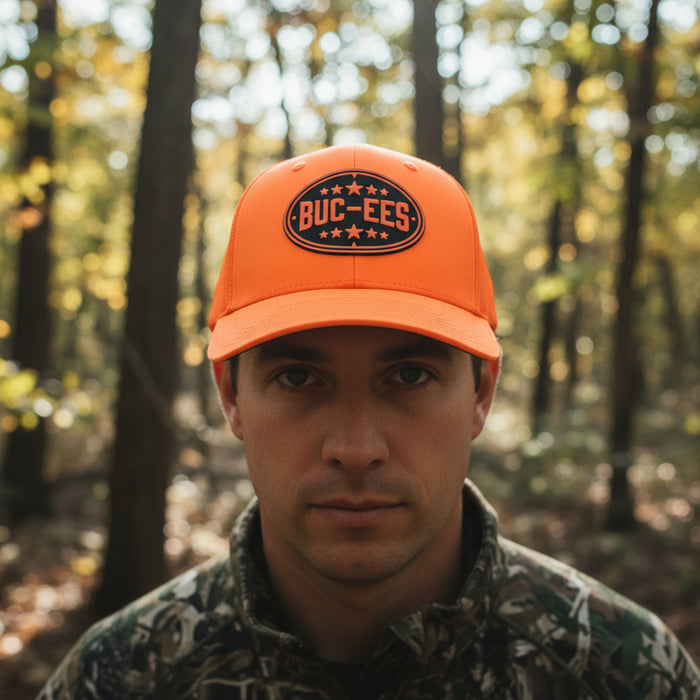 Stand out and stay safe in the great outdoors with the Buc-ee’s Orange Hunter Hat. This high-visibility trucker cap features a bright fluorescent orange color that’s perfect for hunting, hiking, or any adventure where you want to be seen. The front panel sports a bold Buc-ee’s oval logo in black with stars for a classic, rugged look, while the mesh back keeps things cool and breathable. With an adjustable snapback closure, this hat fits most head sizes comfortably.