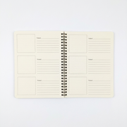An open view of the Buc-ee's Passport Book interior. The cream-colored pages feature blank square frames for photos or stickers next to lined sections for "Visited" location details and notes. Displayed on a clean white background.