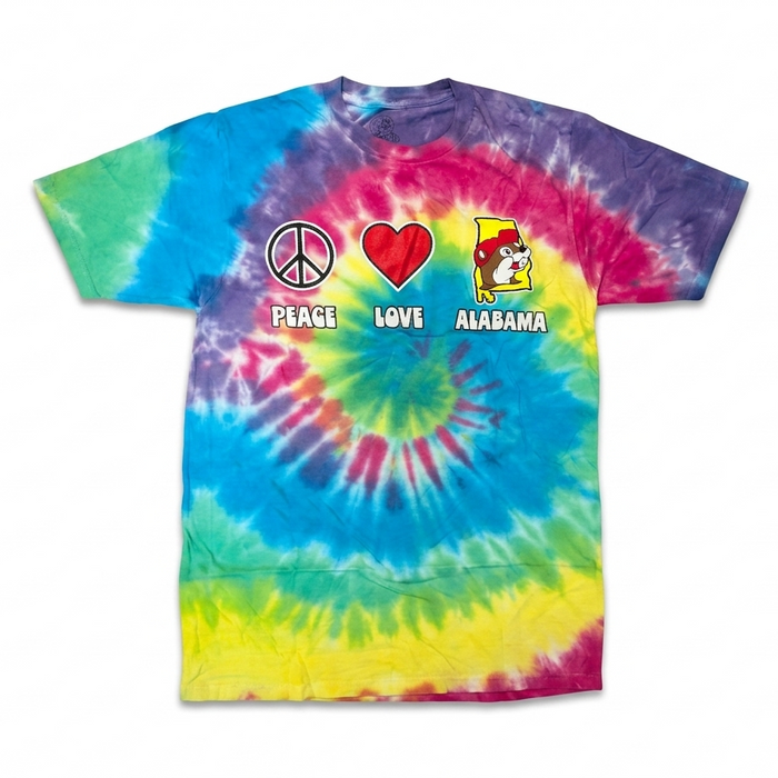 A colorful rainbow spiral tie-dye short-sleeve t-shirt laid flat against a white background, featuring three graphic icons across the chest: a peace sign, a red heart, and a yellow silhouette of Alabama with the Buc-ee's beaver mascot.