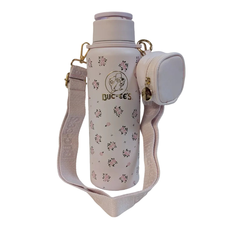Front view of a pastel pink 40 oz Buc-ee's water bottle with an all-over pink rose pattern, displayed on a clean white background. It features a metallic gold Buc-ee's logo on the front and is attached to a wide pink crossbody shoulder strap with a small, matching zippered coin pouch.
