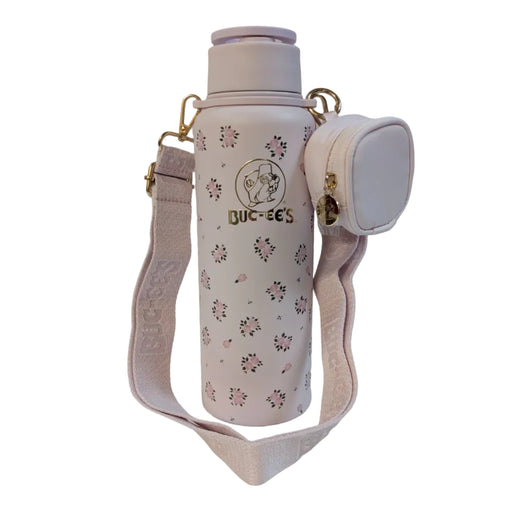 Front view of a pastel pink 40 oz Buc-ee's water bottle with an all-over pink rose pattern, displayed on a clean white background. It features a metallic gold Buc-ee's logo on the front and is attached to a wide pink crossbody shoulder strap with a small, matching zippered coin pouch.