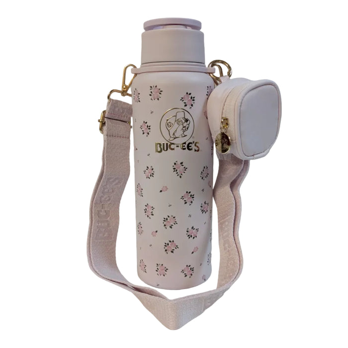Front view of a pastel pink 40 oz Buc-ee's water bottle with an all-over pink rose pattern, displayed on a clean white background. It features a metallic gold Buc-ee's logo on the front and is attached to a wide pink crossbody shoulder strap with a small, matching zippered coin pouch.