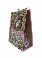 Side view of the Buc-ee’s Pink Leopard Tote Bag showing the large front Buc-ee’s logo with a pink-hat beaver over a leopard print background, pink ‘Buc-ee’s’ text, and solid brown side panel with pink Buc-ee's text bordered with pink trim, displayed on a clean white background.
