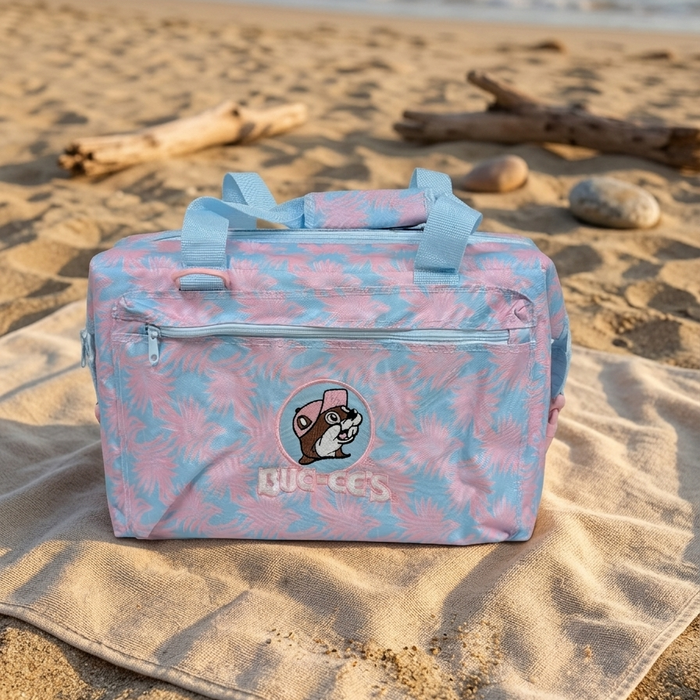 Buc-ee’s Pink Palm 24 Can Cooler on the beach.