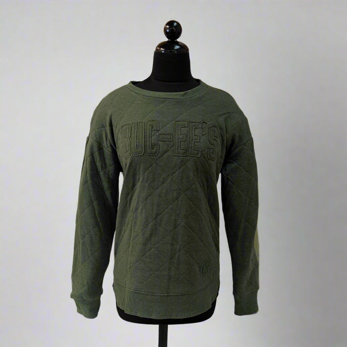 Green sweatshirt on a mannequin against a white backdrop with wooden paneling.