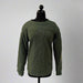 Green sweatshirt on a mannequin against a white backdrop with wooden paneling.