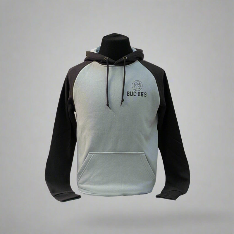 Buc-ee's Raglan Hoodie has a light gray body with black sleeves. It has a small Buc-ee's logo in the top left corner with the words Buc-ee's right under it. 