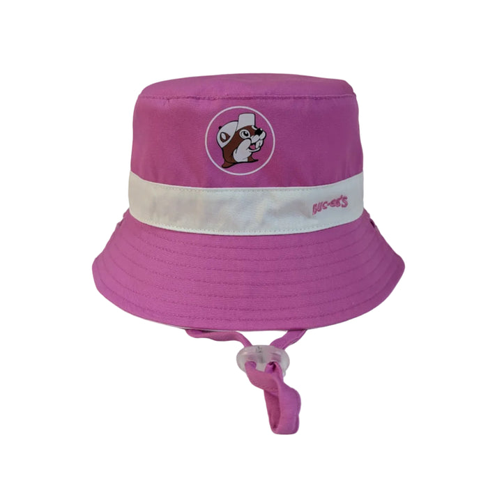 A vibrant pink infant bucket hat featuring a white contrast band around the crown. The center of the crown displays a circular Buc-ee’s logo with the beaver wearing a white hat, and the word "BUC-EE'S" is embroidered in pink on the white band. It includes a matching pink chin strap with a clear adjustable toggle.