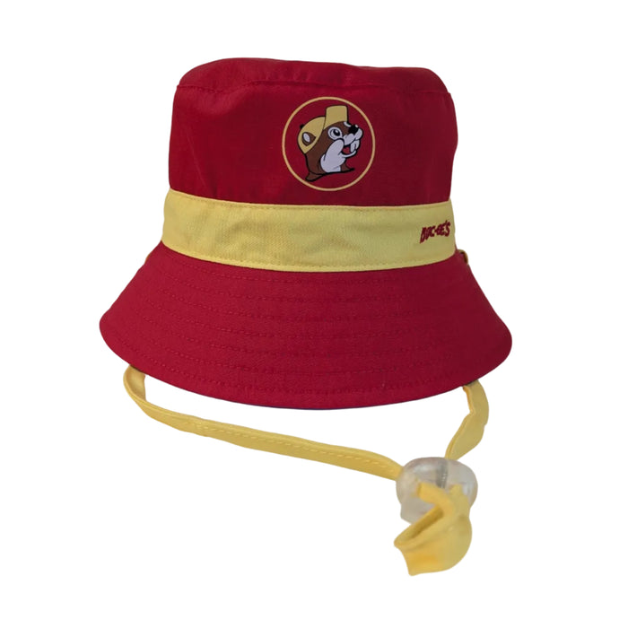A bold red infant bucket hat with a yellow contrast band around the center. The circular Buc-ee’s logo on the crown features the beaver in a yellow hat, while the yellow band is embroidered with "BUC-EE'S" in red. A yellow chin strap with a clear toggle is attached.