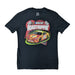 A flat-lay product photograph of a black short-sleeve t-shirt. The center features a vibrant graphic of a red and yellow NASCAR stock car with the number 82 and a Buc-ee’s logo on the hood. The words 'NASCAR' and 'ROAD TRIPPIN’' are displayed above the car against a backdrop of checkered flags and red speed lines. Displayed on a clean white background.