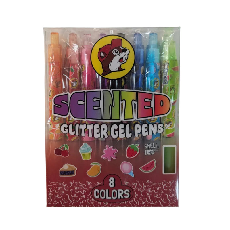 A packaged set of Buc-ee’s Scented Glitter Gel Pens featuring 8 different colored pens inside a clear plastic sleeve. The packaging prominently displays the yellow Buc-ee’s beaver logo at the top and the text "SCENTED GLITTER GEL PENS" in colorful, bubbly letters. Below the pens, the box shows fun, small graphic illustrations of the scents, including a cherry, cupcake, strawberry, mango, slice of pie, cotton candy, and a watermelon slice. The bottom of the box highlights "8 COLORS" in a bold red badge.