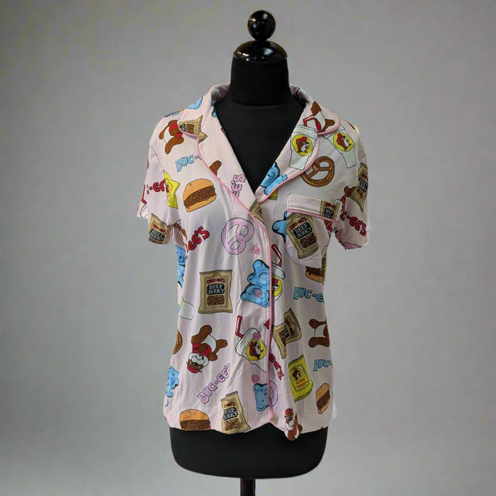 Buc-ee’s Snacks Pajama Top on a mannequin, featuring colorful snack-themed print with Buc-ee’s logo and button-up design.