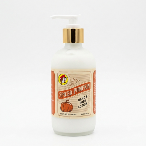 A square, close-up photograph of a bottle of Buc-ee's "Spiced Pumpkin" hand and body lotion centered against a solid white background. The bottle is made of frosted glass containing white lotion, topped with a shiny gold collar and a white pump dispenser. The vintage-style cream paper label features the Buc-ee's beaver logo, the words "SPICED PUMPKIN" in bold red text, an illustration of an orange pumpkin, and text reading "HAND & BODY LOTION," "NET WT. 8 FL OZ. (236 ML)," and "MADE IN THE USA."