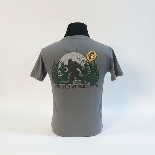 The Buc-ee’s “Spotted at Buc-ee’s” Shirt captures the legendary moment Bigfoot was seen grabbing snacks under the Texas stars. Featuring a classic gray tee with a bold Buc-ee’s logo on the front and a mysterious Bigfoot silhouette against a moonlit forest on the back, this shirt is perfect for fans of roadside adventures and tall tales alike.