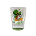 A clear glass shot glass with a green base. The front features the Buc-ee's beaver mascot wearing a green leprechaun hat and a yellow bow tie, with the year "2026" printed on a golden banner below him, displayed on a clean white background.