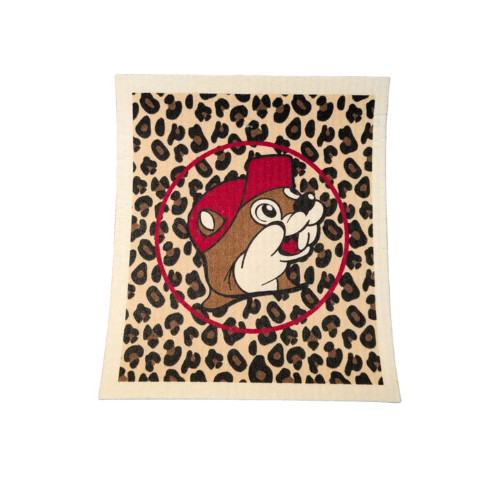 A square Swedish dishcloth featuring a tan and black leopard print background. Centered on the cloth is the Buc-ee's beaver mascot framed by a thin red circle.