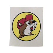 A square, textured white Buc-ee's Swedish dishcloth featuring a large, centered print of the iconic round yellow logo with the smiling beaver cartoon mascot wearing a red cap, displayed on a white background.