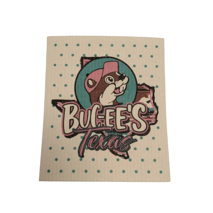 A square Swedish dishcloth with a cream background covered in teal polka dots. The center features a teal graphic of the state of Texas with the Buc-ee's beaver mascot in a pink cap and the text "Buc-ee's Texas."