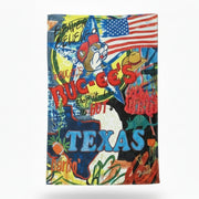 Buc-ee’s Texas plush blanket with colorful collage design, American flag, Buc-ee the Beaver graphic, and large “TEXAS” lettering laid flat and displayed on a clean white background.