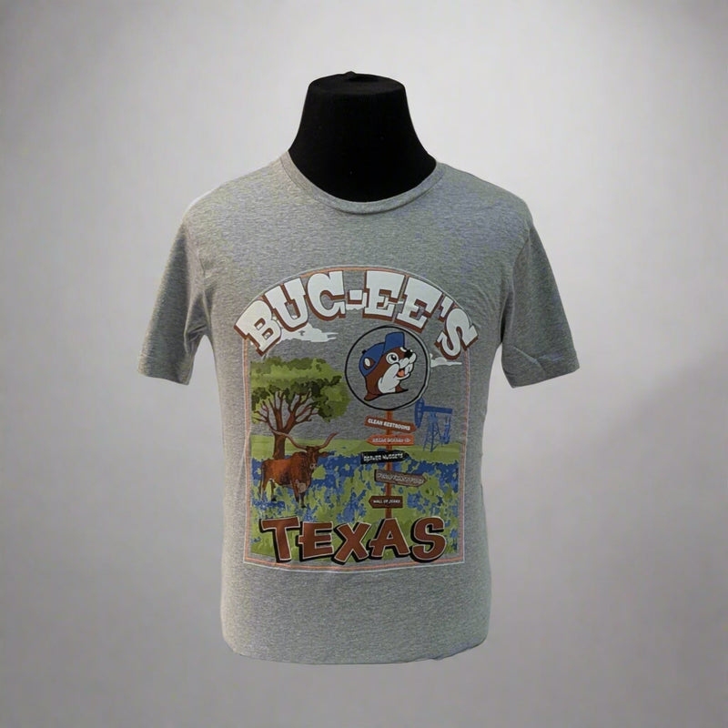 Show off your Lone Star pride with the Buc-ee’s Texas Signpost Shirt. This heather gray tee features a colorful, hand-painted style graphic of a Texas landscape — complete with a signpost pointing to iconic Texas spots, a longhorn, bluebonnets, and of course, the one and only Buc-ee’s beaver.

