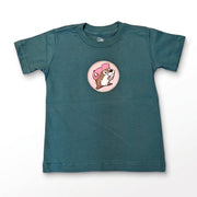 A dark teal green short-sleeve kids' t-shirt with a circular graphic of a cartoon dog wearing a pink hat on the chest, displayed flat against a white background.