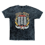 The back of a Buc-ee's Tour Tee 2026, a black mineral-wash t-shirt featuring a large, concert-style graphic titled "BUC-EE'S 2026 ROAD TOUR." The center contains a comprehensive, three-column list of Buc-ee’s locations and their opening years, starting from 1982 in Lake Jackson, TX, through 2026. The list is framed by golden lightning bolts and electric guitars, with a small Buc-ee's beaver logo set inside a star with white wings at the bottom.
