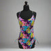 Buc-ee's Tropical One Piece Swim Suit. With Purple, Pink, blue, and yellow palm leaves and Buc-ee's Logo. 