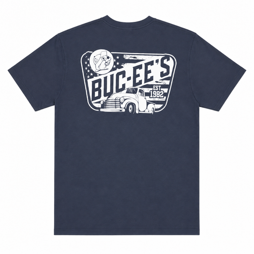 Back view of a navy blue Buc-ee’s T-shirt featuring a large distressed white vintage graphic with bold “BUC-EE’S” lettering, “EST. 1982,” a beaver emblem, stars, and a classic pickup truck, displayed on a clean white background.