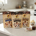 Three standing pouches of Buc-ee's Waffle Cones—Milk Chocolate & Cookie Butter, Dark Chocolate, and Milk Chocolate—are lined up on a white kitchen counter. To the right of the bags sits a small bowl of vanilla ice cream alongside ice cream toppings, including a small dish of rainbow sprinkles, and a jar of chocolate sauce.