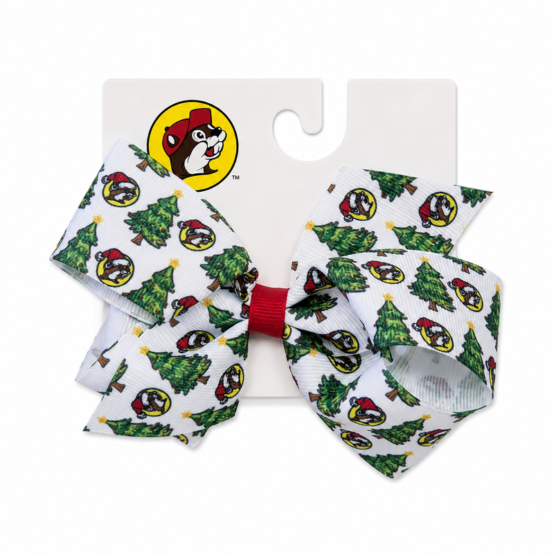 White Christmas hair bow with green Christmas tree and Santa-hat mascot pattern, red center wrap, shown on a white retail card against a clean white background.