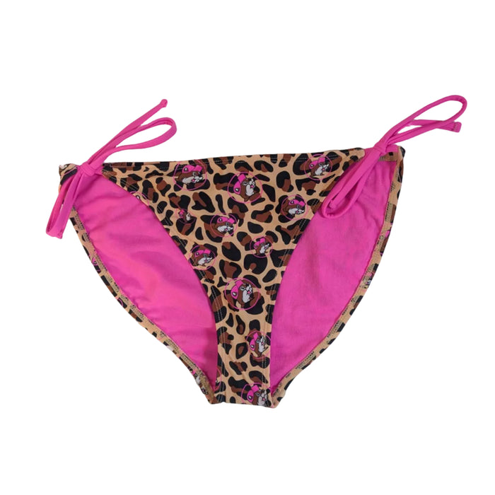 A pair of Buc-ee's women's Leopard bikini bottoms featuring an all-over brown and black leopard print. The pattern is interspersed with small pink circular icons of the Buc-ee's beaver mascot wearing a pink hat. The bottoms feature adjustable, vibrant pink string ties at the hips and a matching pink interior lining visible at the edges, swimsuit displayed on a clean white background.