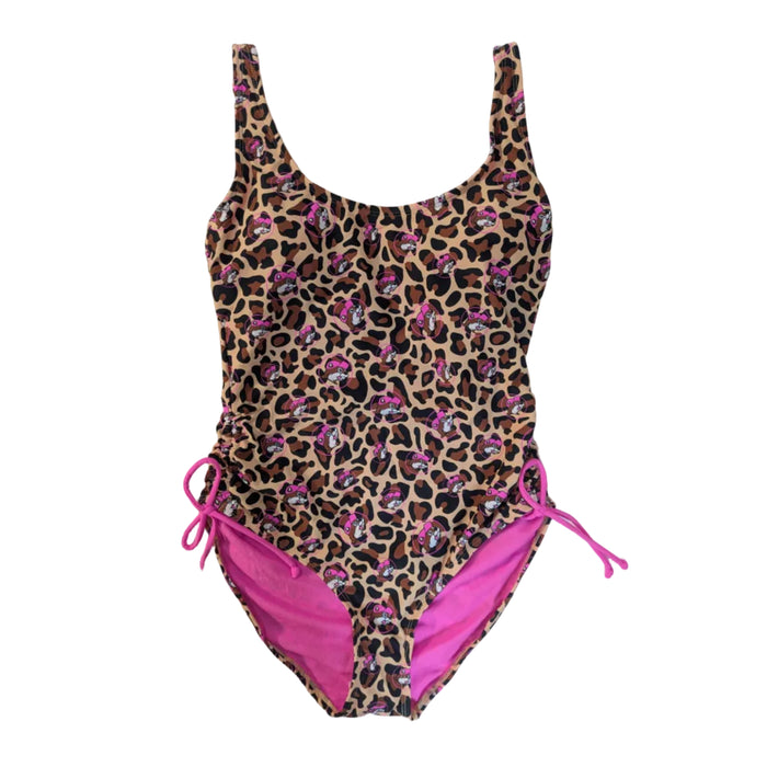 A Buc-ee's women's Leopard one-piece swimsuit with an all-over leopard print and pink Buc-ee's beaver mascot icons. The suit features a scoop neckline and adjustable bright pink drawstring ties at the hips that create a cinched effect, revealing a pink interior lining, swimsuit displayed on a clean white background.