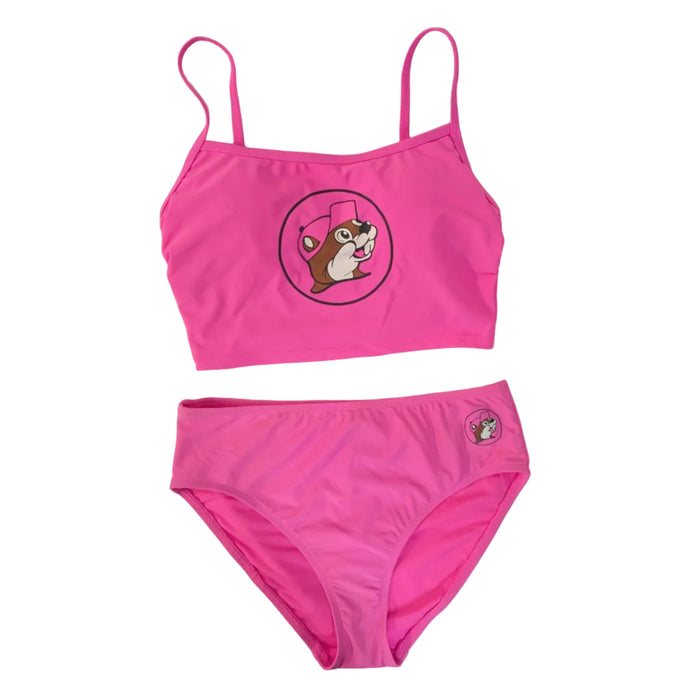 A product photo of a Buc-ee's Women's Pink Logo Swim Set. The set includes a cropped tankini top featuring a large Buc-ee beaver mascot logo and matching mid-rise bikini bottoms with a smaller logo on the hip, all displayed on a clean white background.