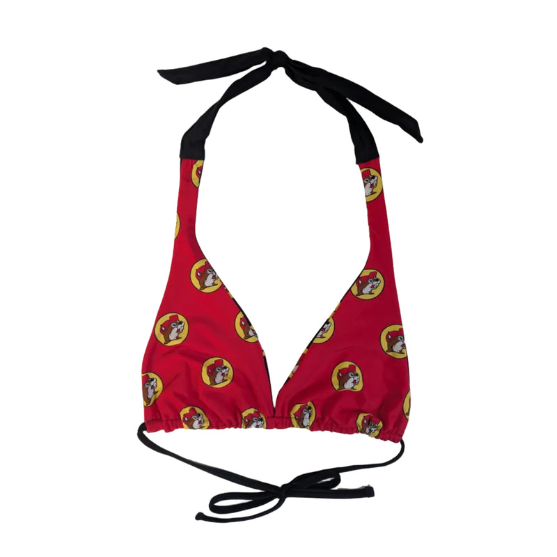 A Buc-ee's Red Logo Reversible Bikini Top . A classic triangle-style bikini top showing the red side with black halter neck and back ties, repeating pattern of the iconic yellow and red Buc-ee’s beaver logo. All displayed on a clean white background.