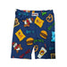 A product photograph of a pair of Buc-ee's youth pajama shorts centered on a clean white background. The dark blue shorts feature a flexible elastic waistband and an all-over cartoon print of Buc-ee the Beaver alongside iconic road trip treats, including bags of Beaver Nuggets, beef jerky, sliced brisket sandwiches, gummy bears, pretzels, and fountain drinks.