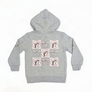 Light grey youth hoodie showing a back grid graphic of Buc-ee mascot logos alternating with pastel pink ribbon bows.