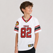 Youth wearing a white Buc-ee’s football jersey with red, gray, and black striped sleeves, “TEXAS” lettering, a large red “82” on the front, and Buc-ee’s beaver patches.