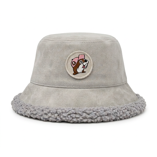 Buc-ee's light gray faux-suede bucket hat with a fuzzy light gray sherpa interior lining and brim trim, featuring a circular front patch of Buc-ee the Beaver wearing a pink cap.