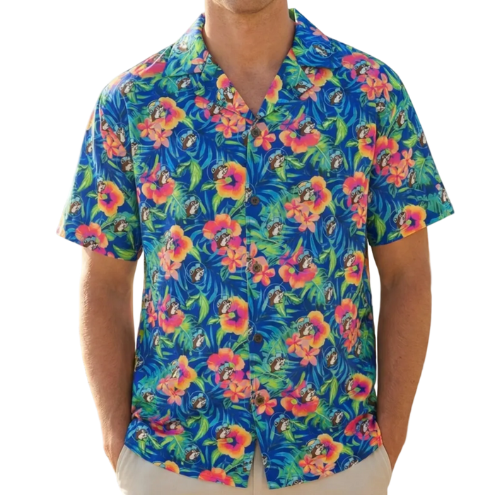 Man wearing a colorful floral shirt on a beach with palm trees.